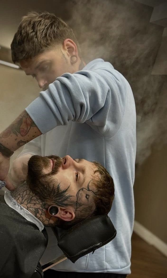 Rory, barber and founder of STANDRD Leamington Spa, finishing a hot towel beard service